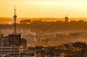 Telecommunication tower with cellular network antenna on city background